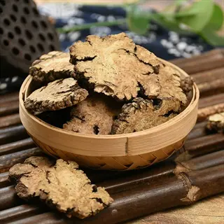 dried lovage root slices in a small bamboo basket on a wooden surface
