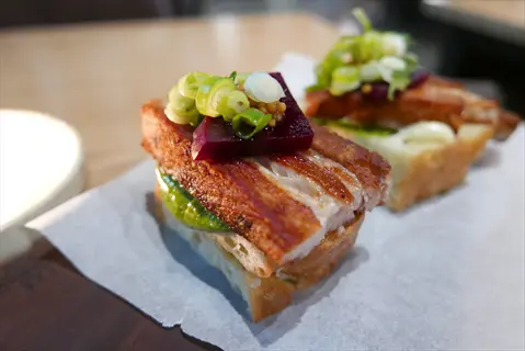 lovage seeds bread topped with crispy pork, beetroot, scallions and mustard seeds