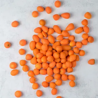 round parisian carrots scattered on a light gray surface